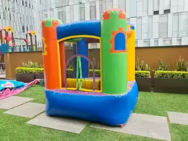 Renta de inflable chico tipo mini castillo montado en la terraza de un edificio residencial en CDMX para una fiesta infantil